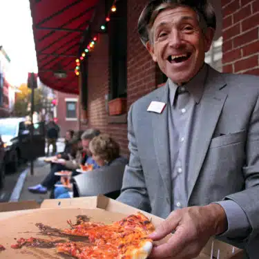 a person holding a slice of pizza