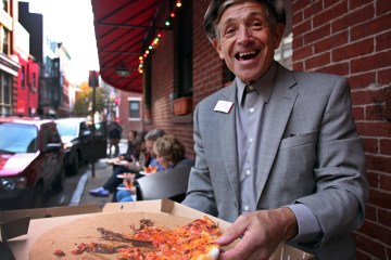 a man holding a slice of pizza